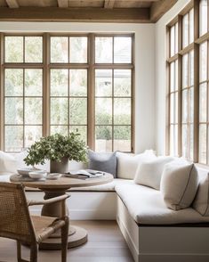 a living room filled with furniture and lots of window sill space next to a table