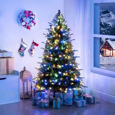 a brightly lit christmas tree with presents under it