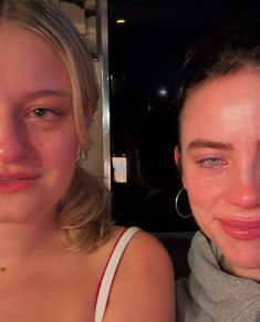 two women are posing for the camera in front of a mirror with their eyes closed