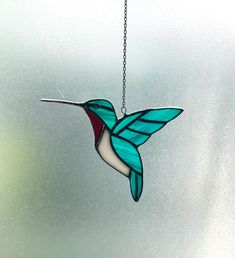 a stained glass hummingbird hanging from a chain