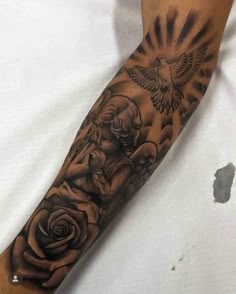 a man's arm with an angel and rose tattoo on the left side of his arm