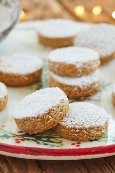 powdered sugar cookies on a plate with christmas lights in the background