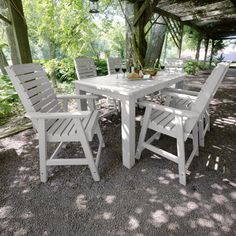 a white table and chairs sitting under a tree