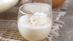 two glasses filled with milk sitting on top of a table