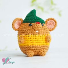 a small crocheted mouse with a green hat on it's head and ears