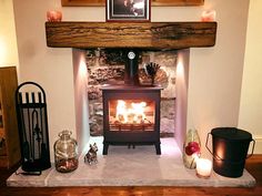 a wood burning stove sitting in a living room next to a wall with pictures on it