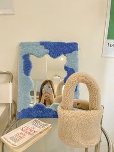 a woman taking a selfie in front of a mirror with a teddy bear inside