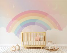 a baby's room with a rainbow wall mural