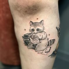 a small raccoon reading a book on the leg with stars around its eyes