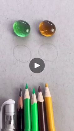 pencils and markers are arranged in front of a face