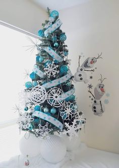 a blue christmas tree decorated with snowflakes and ribbons is featured on the instagram page