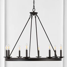 a black chandelier with six candles hanging from the bottom and one light on top