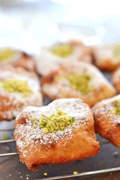 several pastries covered in powdered sugar and pistachio