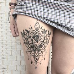 a woman's thigh with a flower tattoo on her leg and the bottom part of her thighs