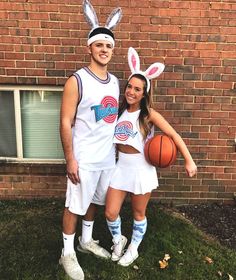 a man and woman in bunny ears standing next to each other with basketballs on their heads