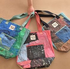 three handmade bags are sitting on the floor