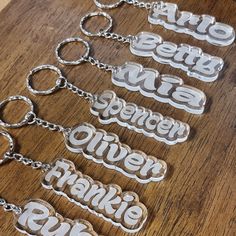 six different metal key chains on a wooden table