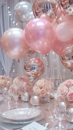 a table topped with lots of pink and white balloons