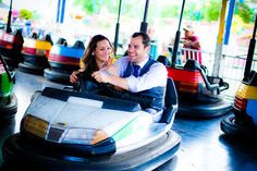 a man and woman are riding on a bumper car at an amusement park or fair