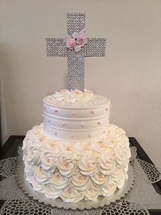 a wedding cake decorated with flowers and a cross