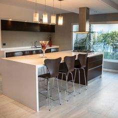 a modern kitchen with an island and bar stools