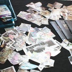 a table topped with lots of different types of papers and pictures next to a laptop