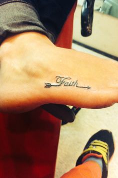 a person with a small tattoo on their arm and foot that says faith in cursive writing