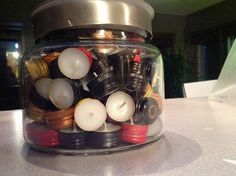 a glass jar filled with lots of different types of electrical wires and plugs on top of a table