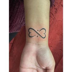 a person's wrist with a tattoo on it that has an infinite sign in the middle