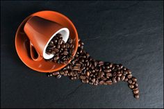 coffee beans spilling out of an orange cup