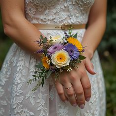 a woman wearing a wedding dress holding a bouquet of flowers in her hands with both hands