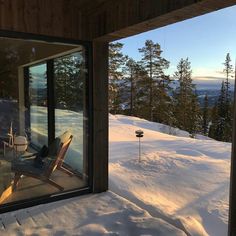 a chair sitting on top of a snow covered slope next to a large glass window