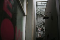 two people are standing on the stairs in an industrial building