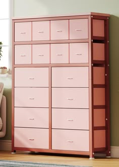 a pink dresser sitting next to a chair in a room