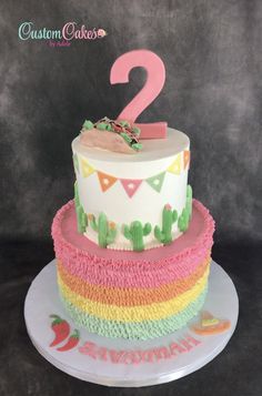 a two tiered cake decorated with colorful icing