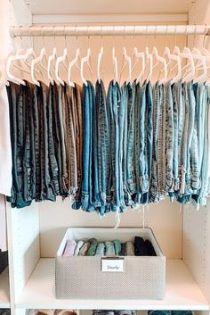 an organized closet with clothes hanging on racks