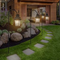 a house with stone steps leading up to the front door and side yard at night