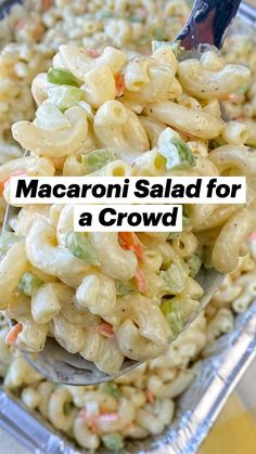 macaroni salad for a crowd in a serving dish with a spoon on it