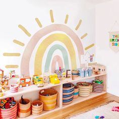 a child's playroom with toys on the shelf and rainbow painted on the wall