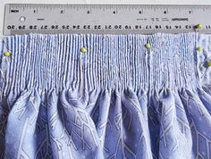 a ruler is next to a curtain with blue and white designs on it's side