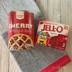 a can of jello next to a box of cherry pie mix on a towel