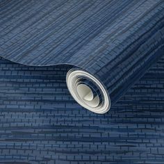 a roll of blue woven fabric on the ground