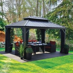 a black gazebo sitting on top of a lush green field