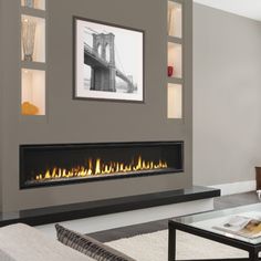 a living room with a fire place in the center and a painting on the wall