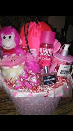 a pink teddy bear sitting on top of a basket filled with personal care and beauty items