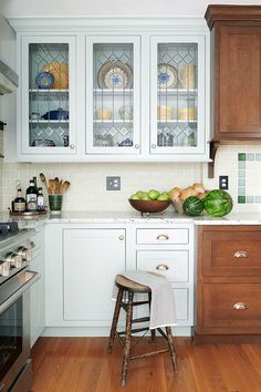 a kitchen with wooden floors and white cabinets