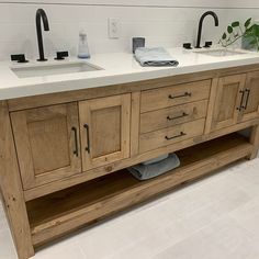 a bathroom with two sinks and wooden cabinets