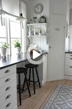 a kitchen with two stools in front of the counter and an area rug on the floor