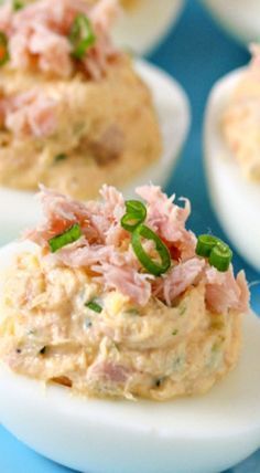 deviled eggs with ham and green onions on them