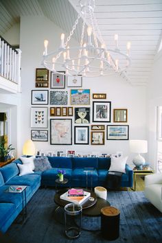 a living room with blue couches and pictures on the wall